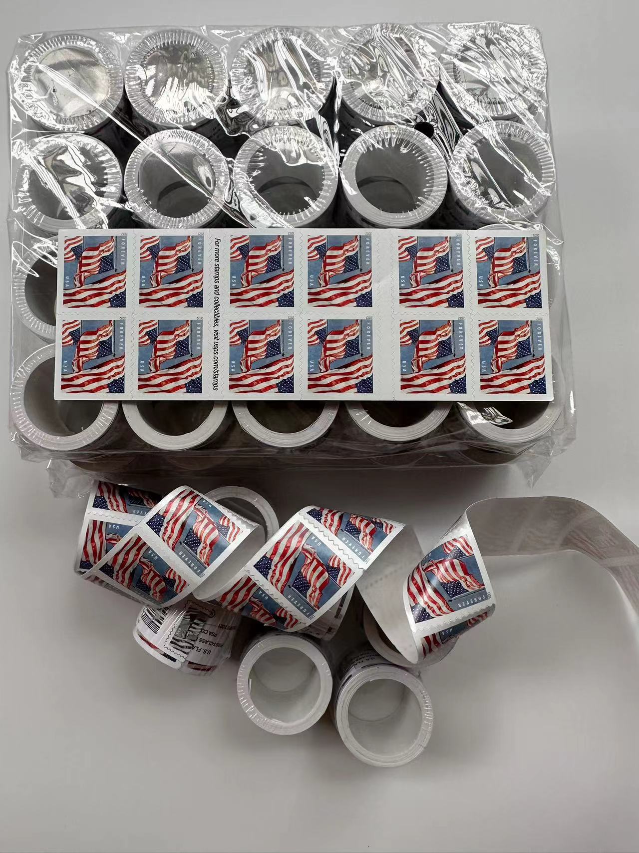 Rolls of U.S. flag Forever stamps arranged for business mailing and everyday letters